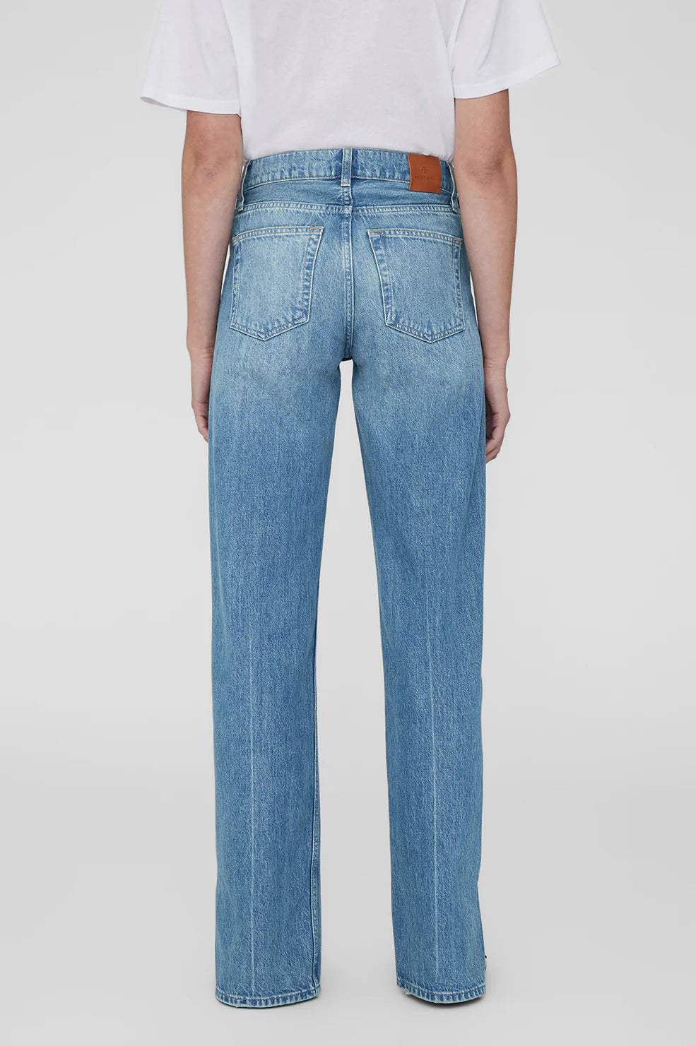 Person wearing blue jeans on a white background