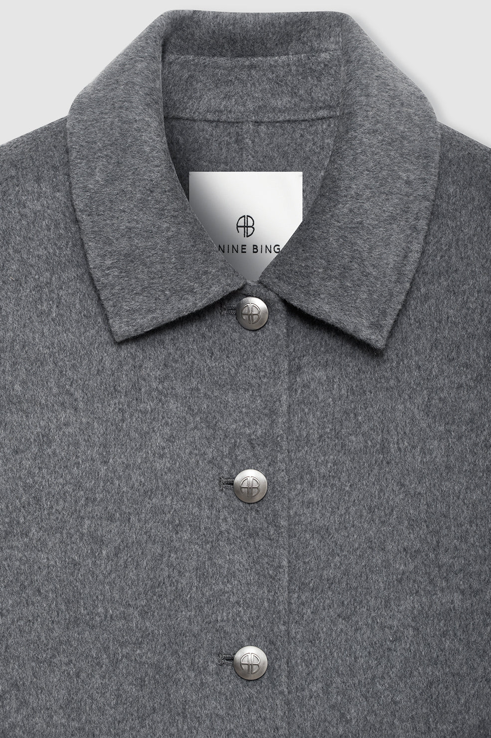 Gray coat with button details and a visible brand label on a light gray background
