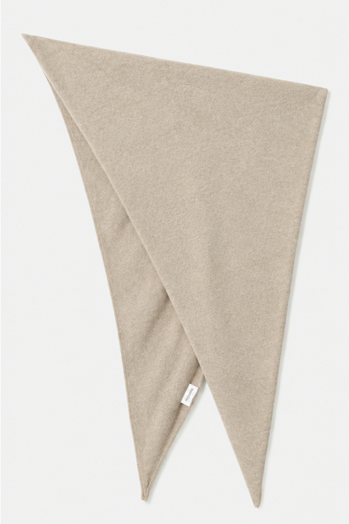 A light beige knit scarf folded diagonally to show its soft texture and double-ended shape, with a small white tag near one tip, set against a clean off-white background.