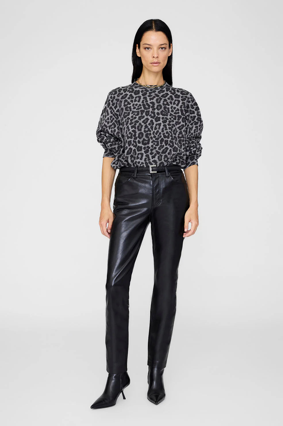 Woman wearing a leopard print top afrom anine bing and black leather pants 