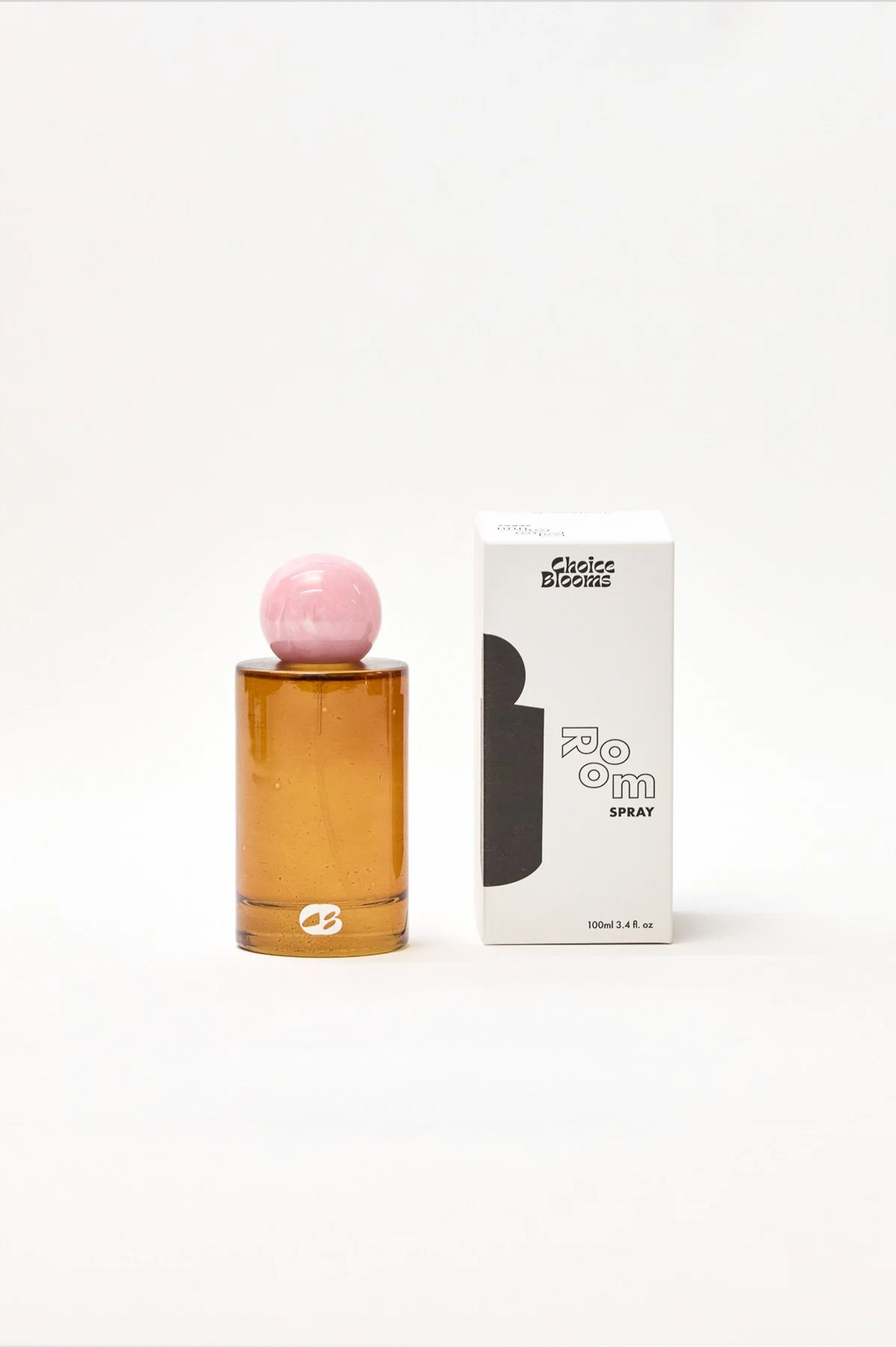 Amber perfume bottle with pink cap and white box on a light gray background