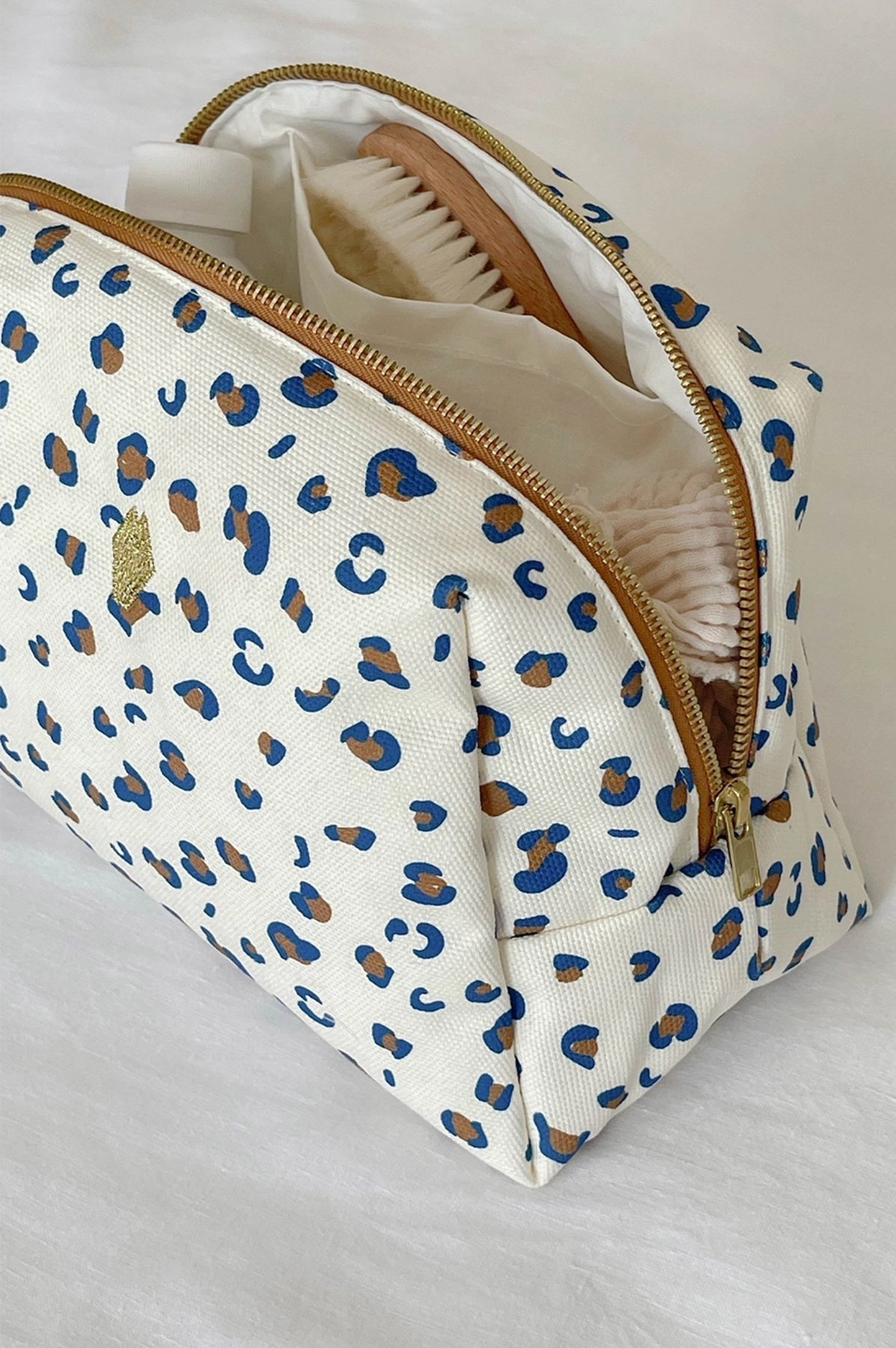 Cosmetic bag with blue leopard print pattern on a white background