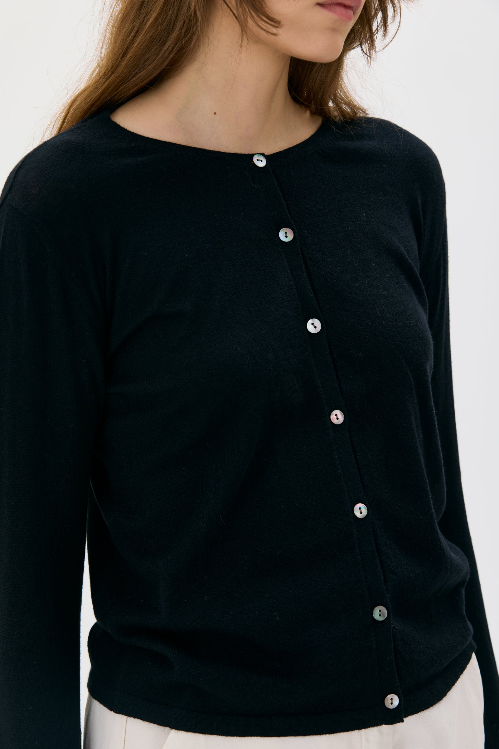 Black cardigan from maska with silver buttons worn by a person on a white background