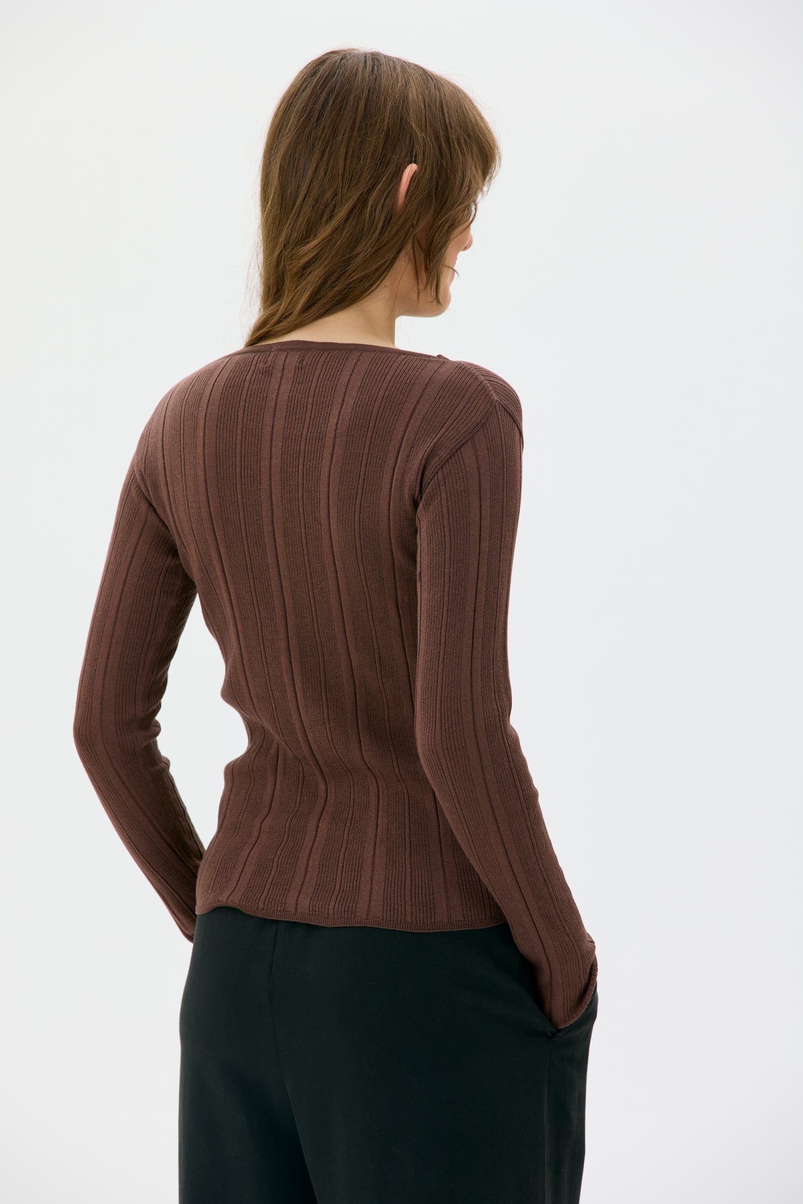 Woman wearing a brown ribbed Minna sweater from maska on a white background