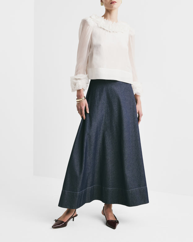 Person wearing a white blouse and navy blue skirt on a white background