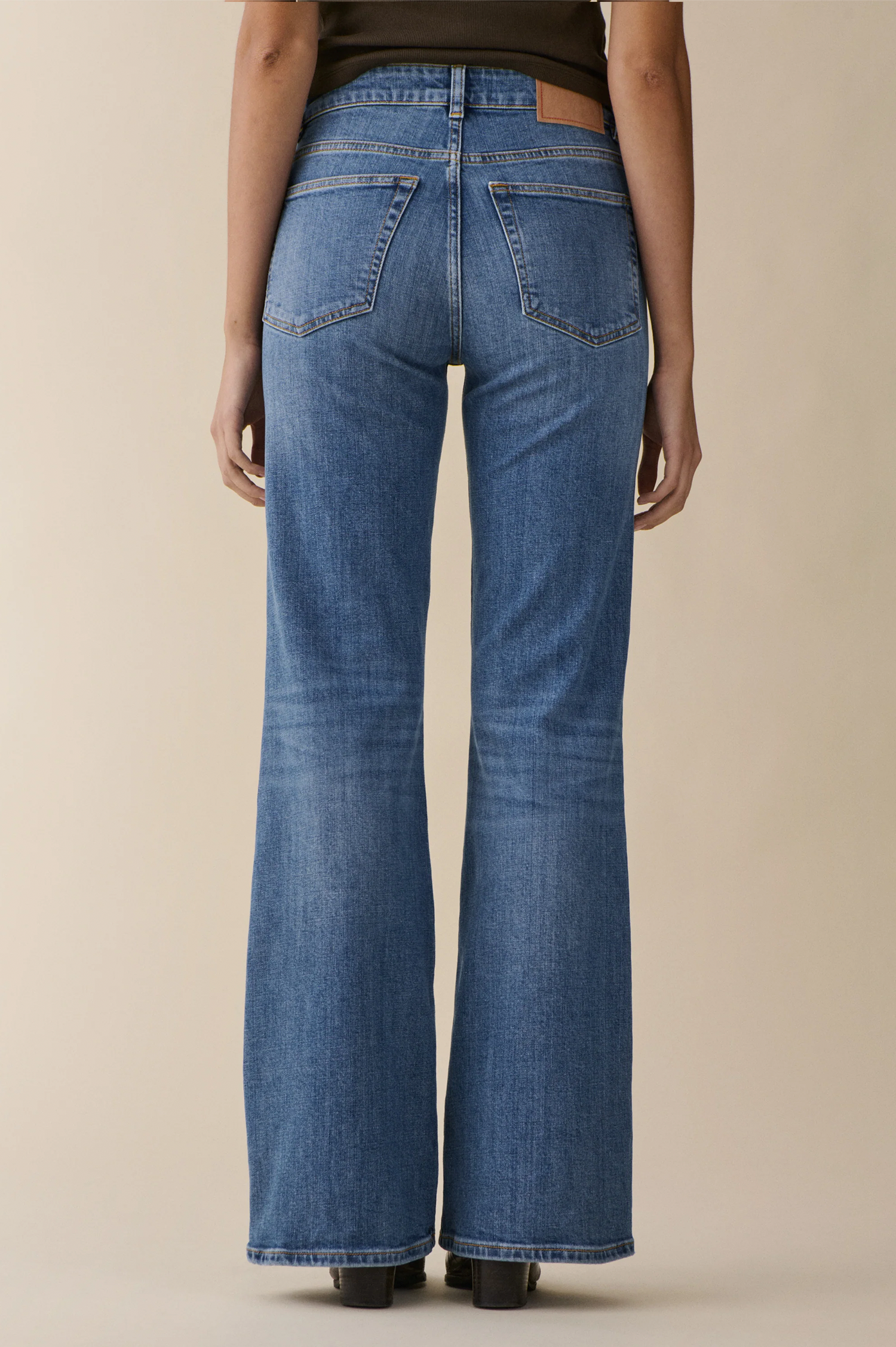 Person wearing vintage blue san babila jeans  from jeanerica on a beige background
