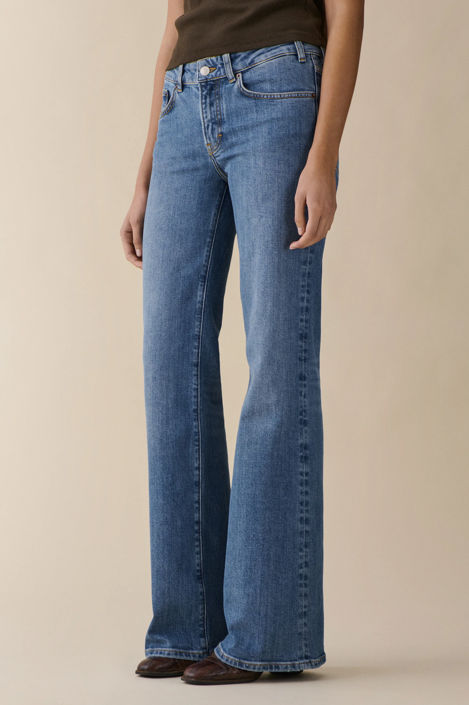 Person wearing san babila jeans from jeanerica in vintage blue on a beige background
